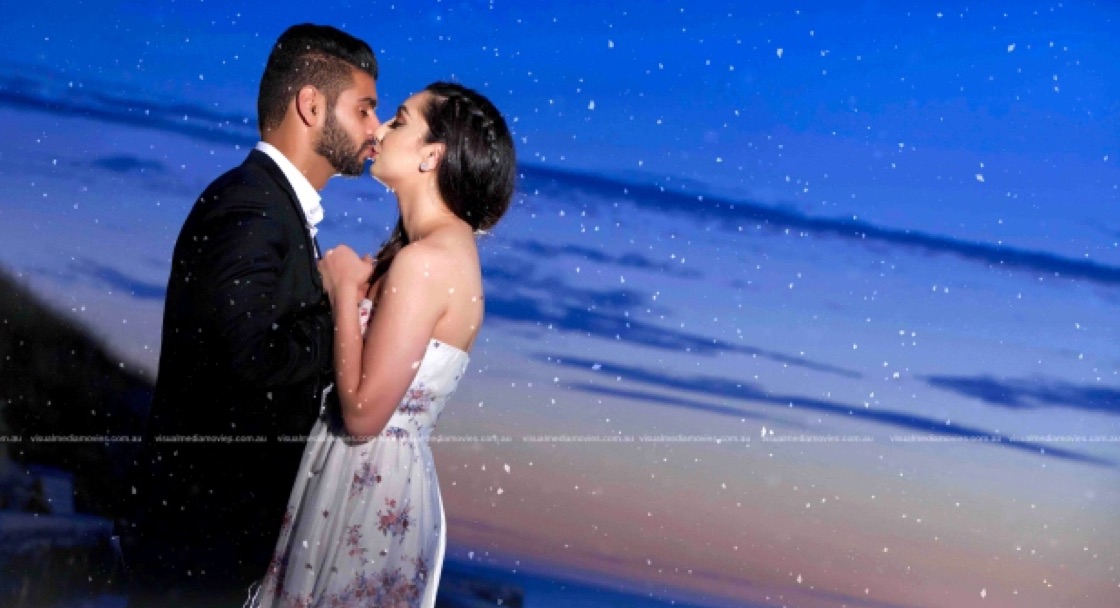 Couple kissing against a deep blue sky at dusk